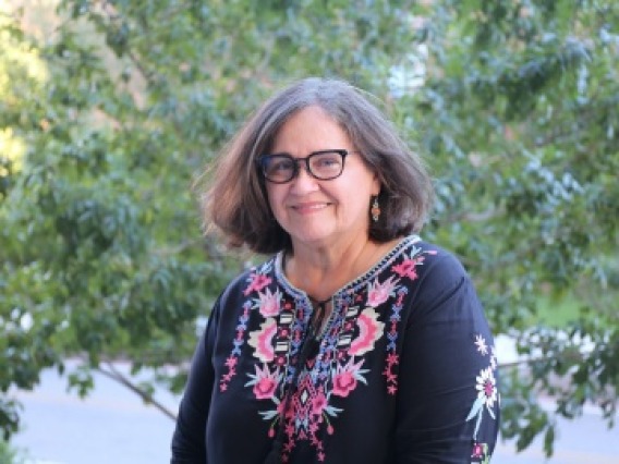 Professor Santa Arias standing outside in front of a tree