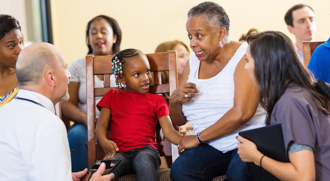 doctor and intern talking with patients in waiting room