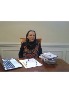 Photo of Dr. Hernandez sitting at a table with her laptop