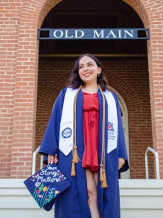 Graduate student Isabella Barron standing in front of Old Main at the University of Arizona.